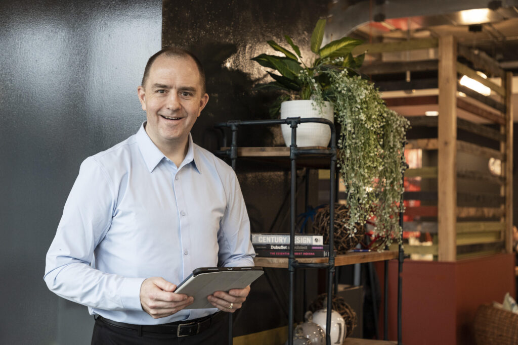 Rich Scott taking notes after a virtual client meeting, smiling at the camera