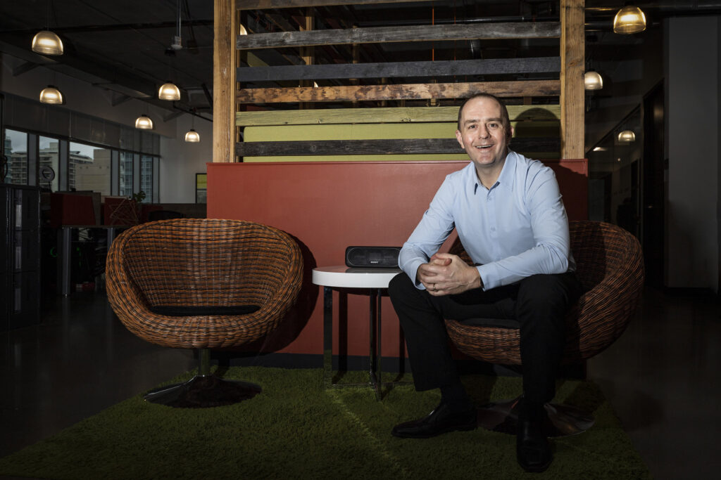 Rich Scott happily sitting on a chair.