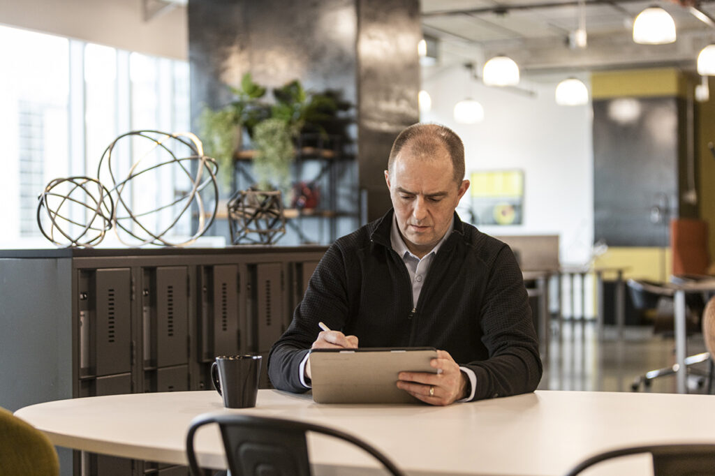 Rich Scott sitting at a table with a tablet device.
